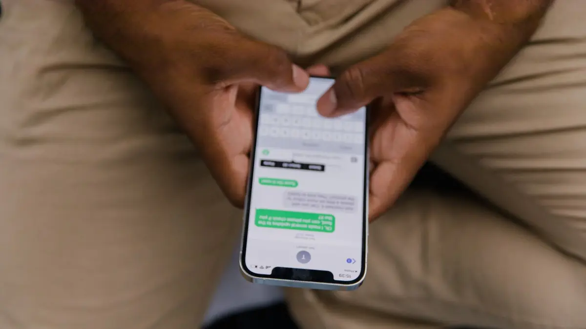 Atendente digitando mensagem de WhatsApp no celular