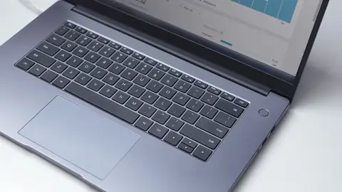 Laptop mostrando painel de analytics com gráficos de visitas