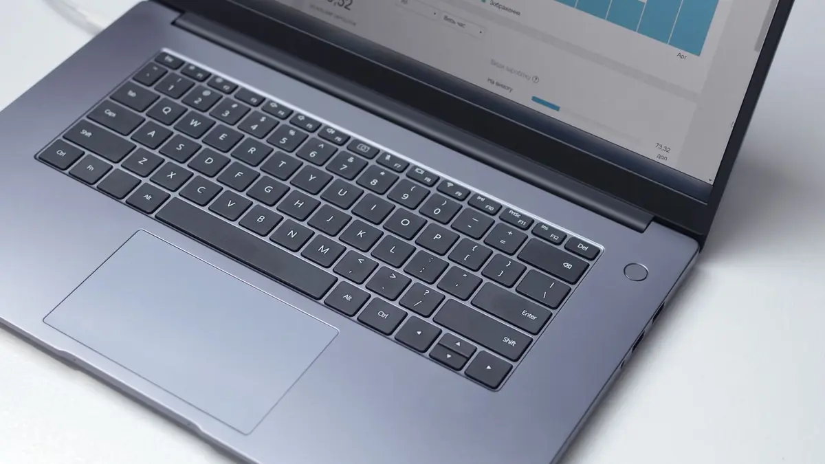 Laptop mostrando painel de analytics com gráficos de visitas