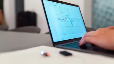 Pessoa analisando gráfico de dados em laptop representando controle de leads
