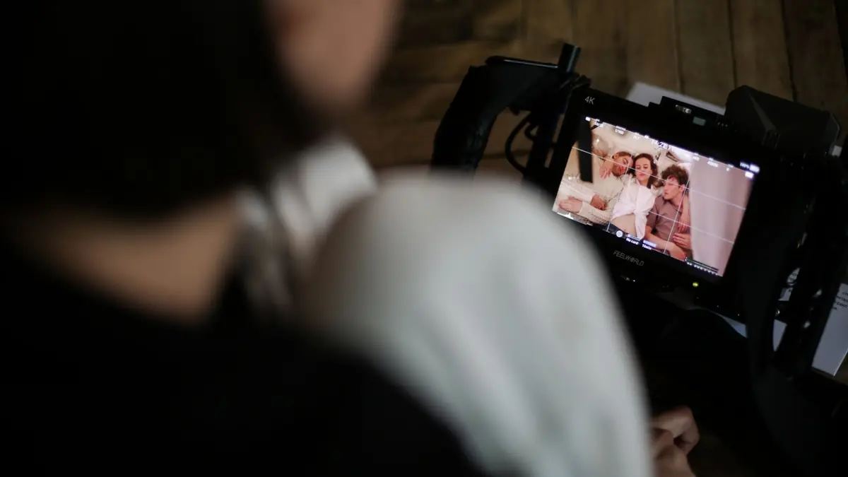 Profissional revisando material de vídeo institucional em monitor