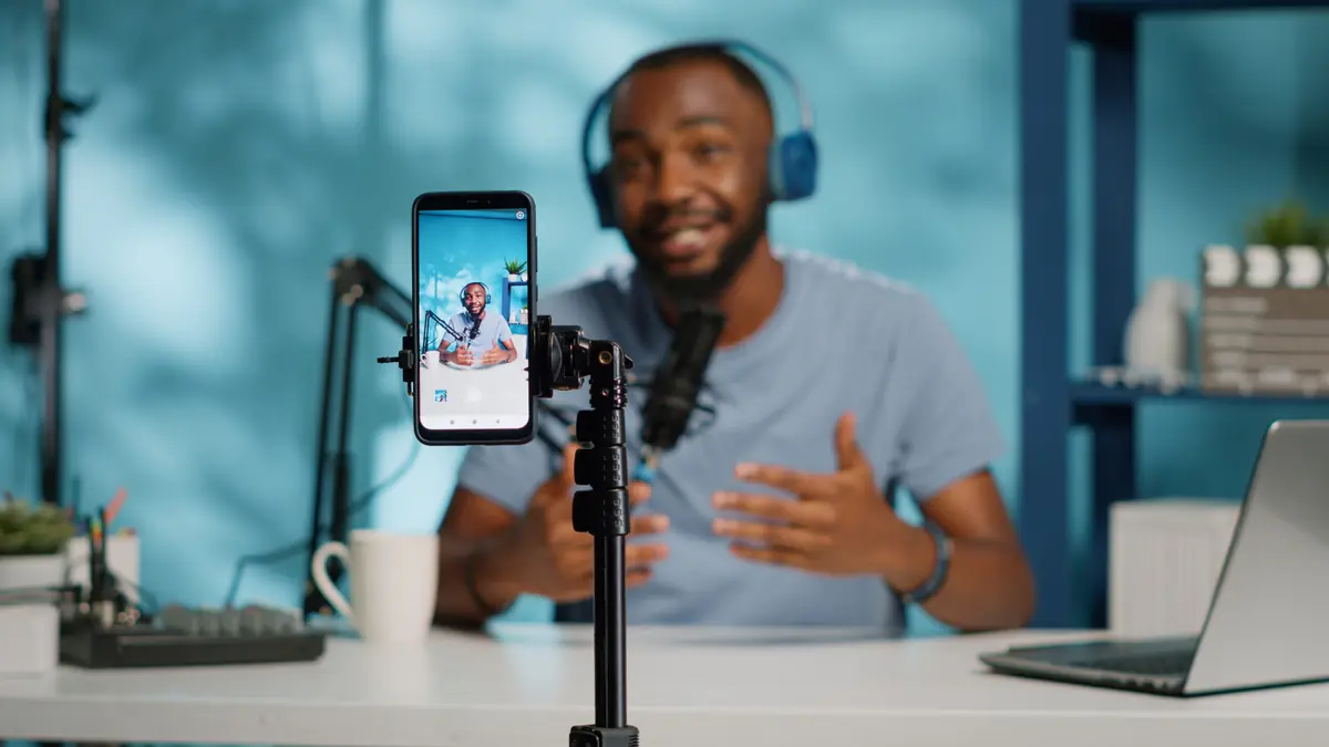 Criador de conteúdo gravando vídeo com celular no tripé
