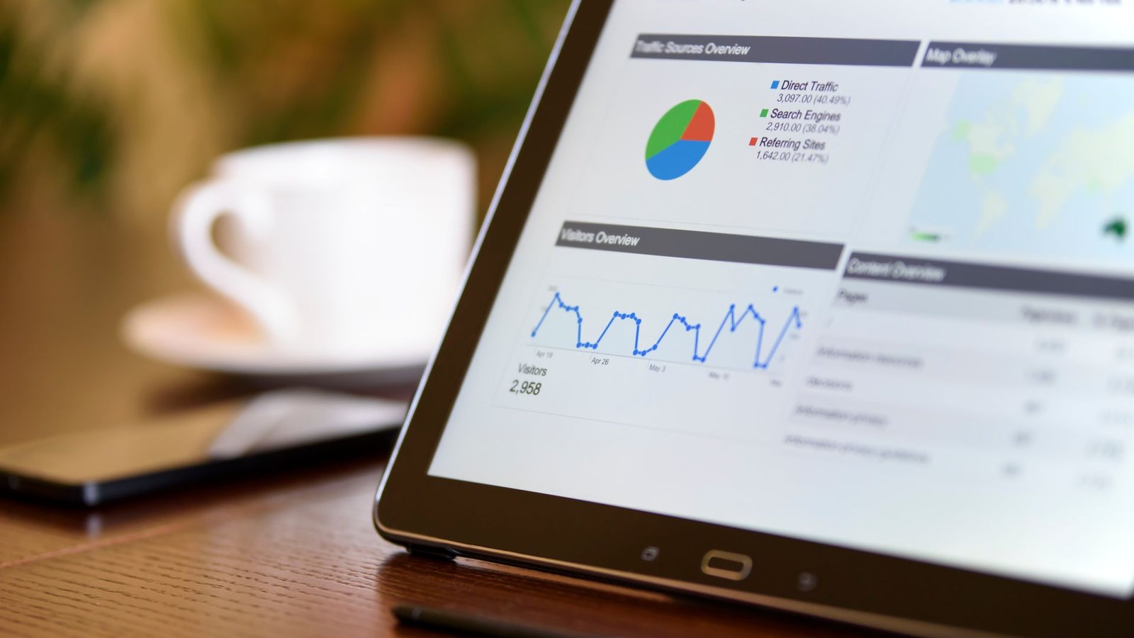 Tablet mostrando gráficos de dados organizados em mesa de escritório